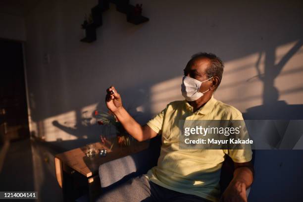 senior man wearing medical mask checking body temperature - quarantine stock pictures, royalty-free photos & images