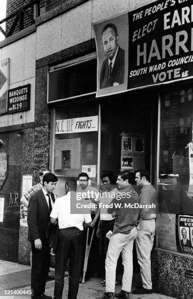 American political activist Tom Hayden speaks with unidentified others outside a Newark Community Union Project storefront, Newark, New Jersey, June...