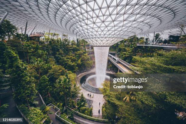 the rain vortex waterfall located inside the jewel changi airport in singapore - changi airport stock pictures, royalty-free photos & images