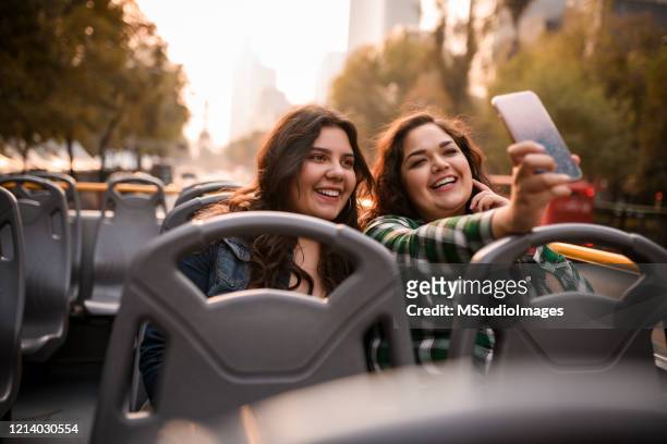 twee jonge toeristen die selfie op de reisbus nemen - dubbeldekker bus stockfoto's en -beelden