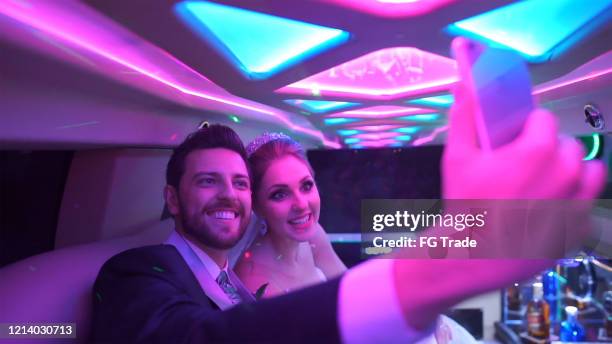 bride and groom having fun and making selfie on the way to the wedding party - wedding limo stock pictures, royalty-free photos & images