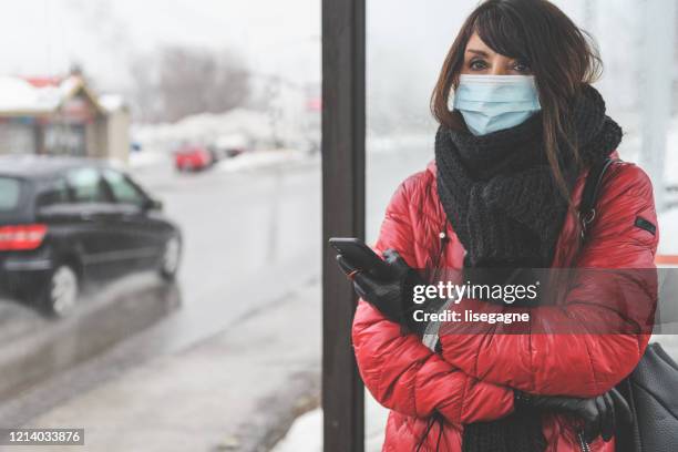 kvinna väntar på bussen - coronavirus winter bildbanksfoton och bilder