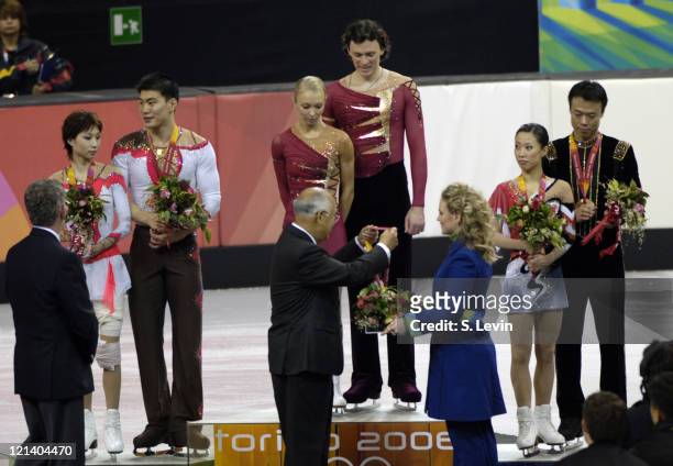 Gold medalist Maxim Marinin and his partner Tatiana Totmianina receive their gold medal along with silver medalists Dan Zhang and Hao Zhang, left and...