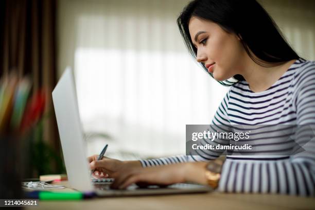young woman working at home - writing list stock pictures, royalty-free photos & images