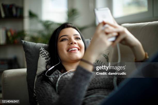 young woman enjoying music at home - get out film 2017 stock pictures, royalty-free photos & images