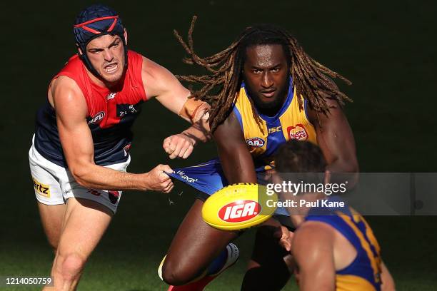 Nic Naitanui of the Eagles gets his handball away while being tackled by Angus Brayshaw of the Demons during the round 1 AFL match between the West...