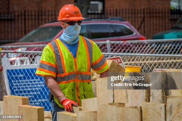 Construction workers wearing protective face masks on site. National Grid resumed the North Brooklyn "MRI" Pipeline construction by allegedly...