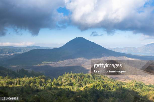 tropical island coastline view from the plane island  agung volcano peak through the clouds seen from a plane's window bali ,indonesia - summit takes place in singapore stock pictures, royalty-free photos & images