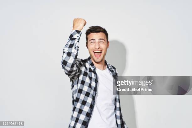 happy young man gesturing shows a yes sign and smiles broadly on a blank background. - portrait of business man looking surprised stock-fotos und bilder