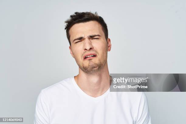 sad young man in a white t-shirt with emotions and sadness and on his face. - pain face portrait bildbanksfoton och bilder