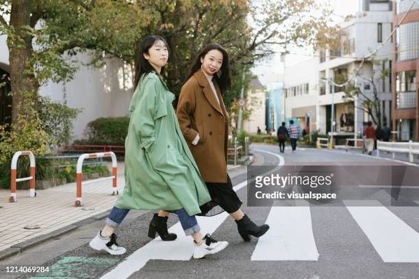 two girls cossing the street - harajuku district stock pictures, royalty-free photos & images
