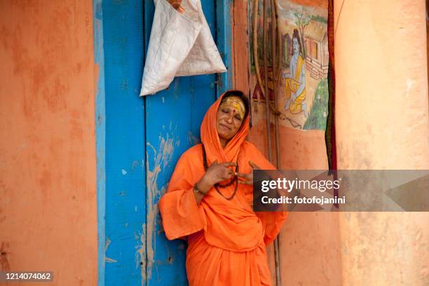 mujer hindú con las manos afectadas por la lepra fuera de su casa en varanasi - lepra fotografías e imágenes de stock
