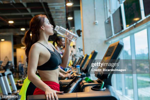 frau macht herz-kreislauf-übung auf einem laufband - musculoso stock-fotos und bilder