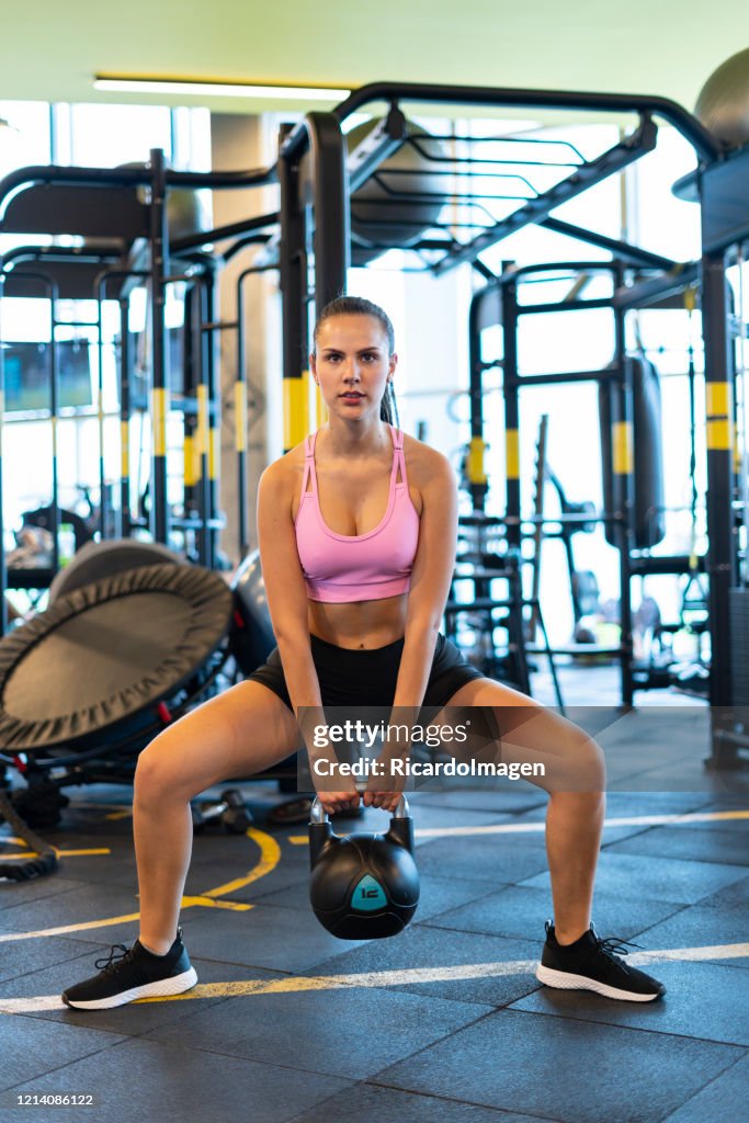 Latin woman using dumbbell in the gym