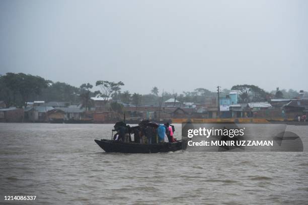 People cross a river on a boat ahead of the expected landfall of cyclone Amphan, in Khulna on May 20, 2020. - India and Bangladesh began evacuating...