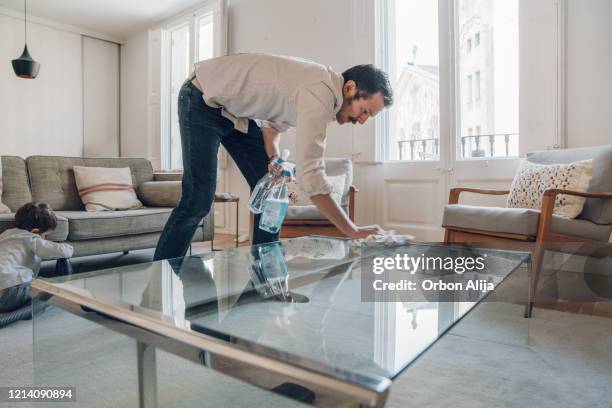 man cleaning table on living room - men housework stock pictures, royalty-free photos & images