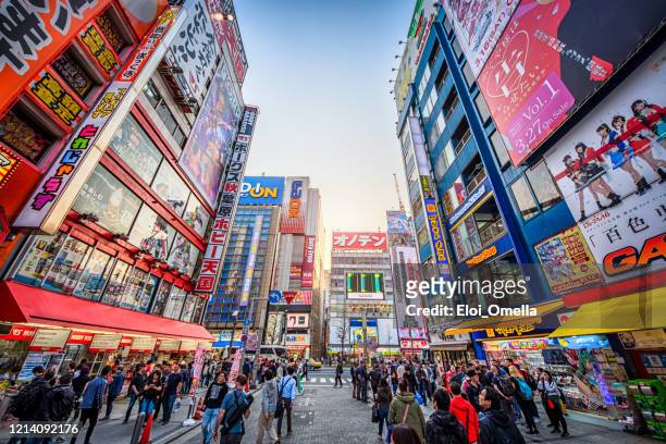 crowded streets of akihabara at sunset, tokyo, japan - akihabara stock pictures, royalty-free photos & images
