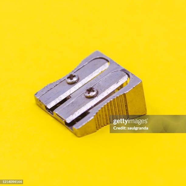 metallic sharpener against yellow background - pencil sharpener stock pictures, royalty-free photos & images