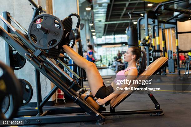 de vrouw van latina die beenpers in de gymnastiek gebruikt - herramientas profesionales stockfoto's en -beelden