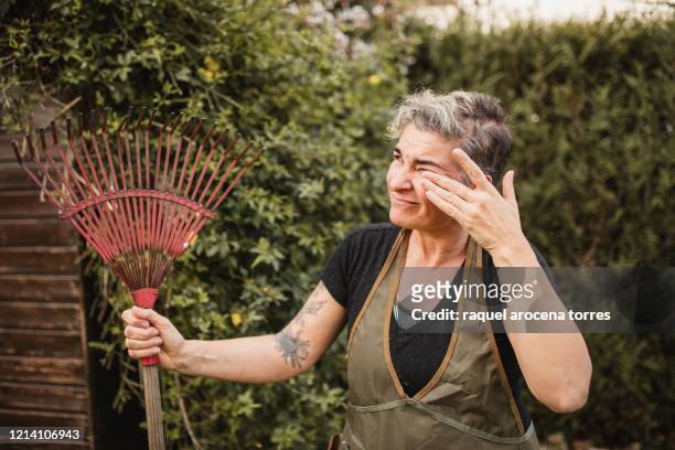adult woman suffering from itchy eyes while working in the garden - tree man syndrome stock-fotos und bilder