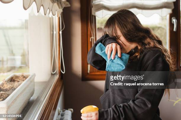 young woman cleaning a house and suffering from spring allergy - picarse la nariz fotografías e imágenes de stock