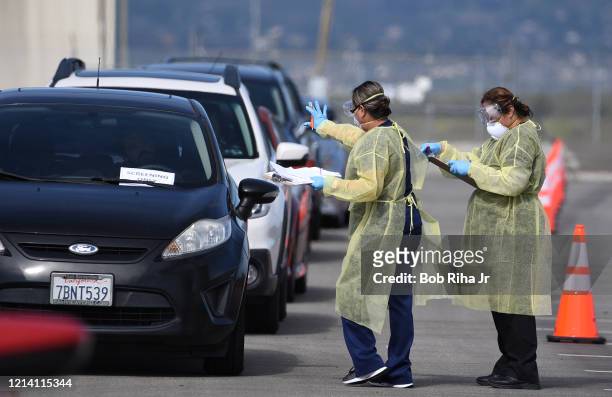 Medical personnel from Riverside University Health Systems hospitals administer a Coronavirus Test to an individual during drive-through testing in...