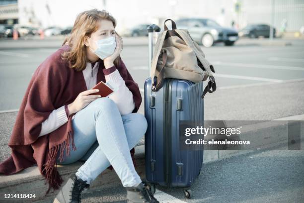 junge frau trägt medizinische maske, mit einem koffer - vacances plage stock-fotos und bilder