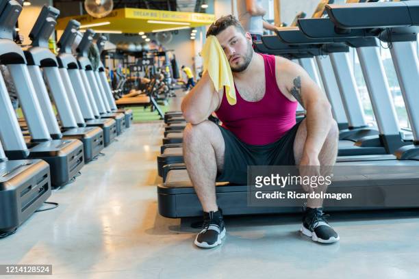 chubby sitting very tired in the gym - hispanoamérica stock pictures, royalty-free photos & images
