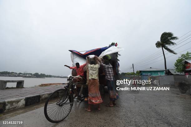 Workers unload goods from a truck ahead of the expected landfall of cyclone Amphan, in Khulna on May 20, 2020. - Several million people were taking...