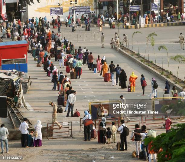 Passengers wait in a long queue to board Rajdhani Express train from Patna to Delhi at Patna Junction, during nationwide lockdown in the wake of the...