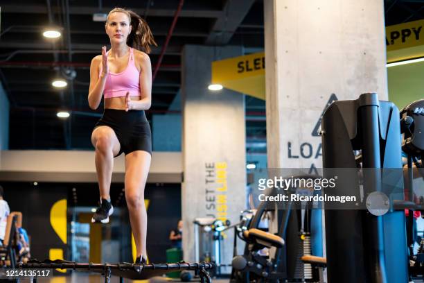 latin woman at the gym exercising on a trampoline - hispanoamérica stock pictures, royalty-free photos & images