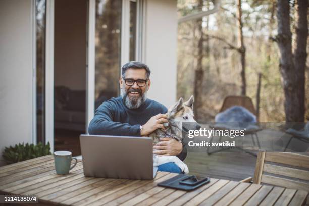 isolatieperiode is draaglijk als je hond hebt - middle age man with dog stockfoto's en -beelden