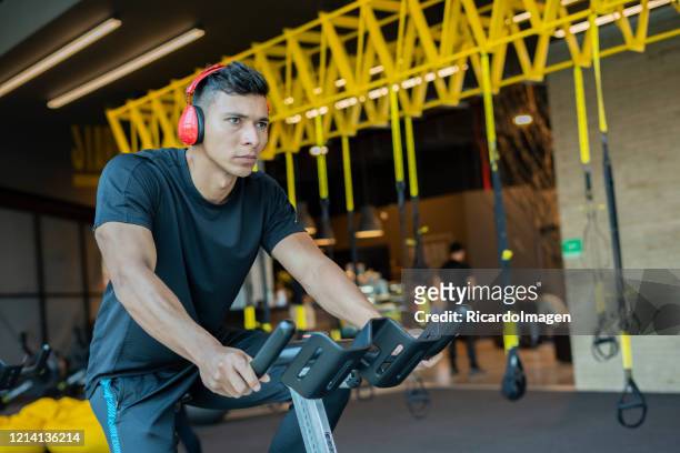 latin man using dumbbell in the gym - hispanoamérica stock pictures, royalty-free photos & images