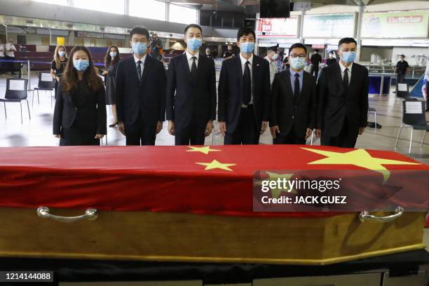 Chinese officials pay their respect in front of the flag-draped coffin of Chinese ambassador Du Wei, who died at his home in the coastal city of...