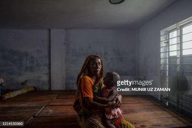 Resident carrying a child rests in a shelter ahead of the expected landfall of cyclone Amphan in Dacope of Khulna district on May 20, 2020. - Several...