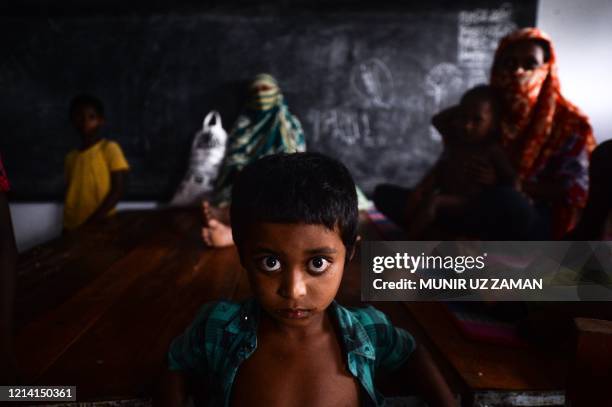 Yound resident rests with others in a shelter ahead of the expected landfall of cyclone Amphan in Dacope of Khulna district on May 20, 2020. -...