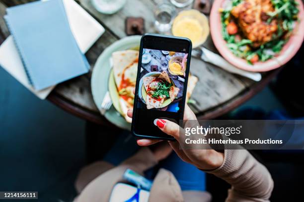 woman taking pics of food using smartphone - photographing foto e immagini stock