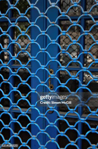 blue metal security shutter on a closed storefront - store closing stock pictures, royalty-free photos & images