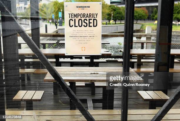 Note to customers is stuck on the window as restaurants close their businesses on March 23, 2020 in Melbourne, Australia. From midday Monday, venues...