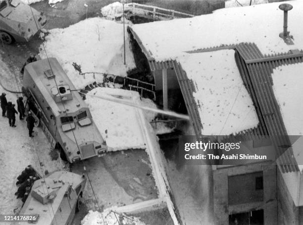 In this aerial image, riot police officers fire water cannon onto the Asama Sanso lodge, where the United Red Army members take a hostage on February...