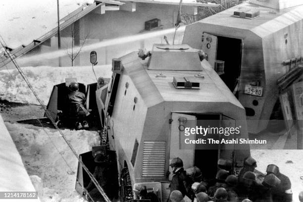 Riot police officers fire water cannon onto the Asama Sanso lodge, where the United Red Army members take a hostage on February 25, 1972 in...