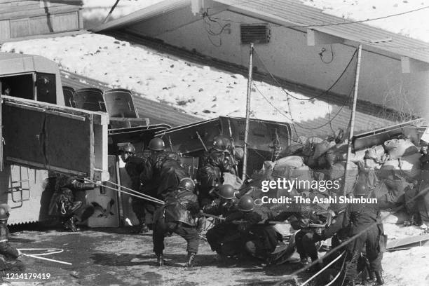 Riot police officers behind sand bag barricade seek a chance to storm into the Asama Sanso lodge as the United Red Army members take a hostage on...