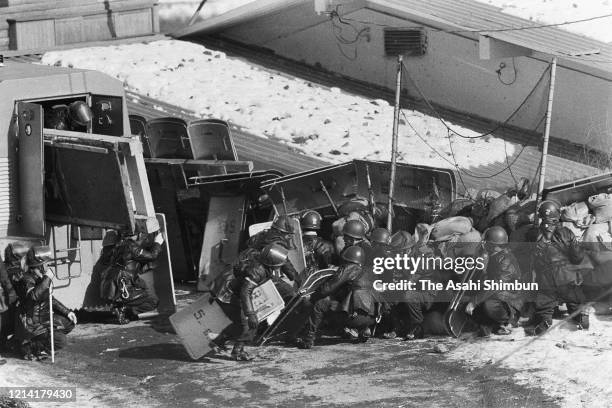 Riot police officers behind sand bag barricade seek a chance to storm into the Asama Sanso lodge as the United Red Army members take a hostage on...