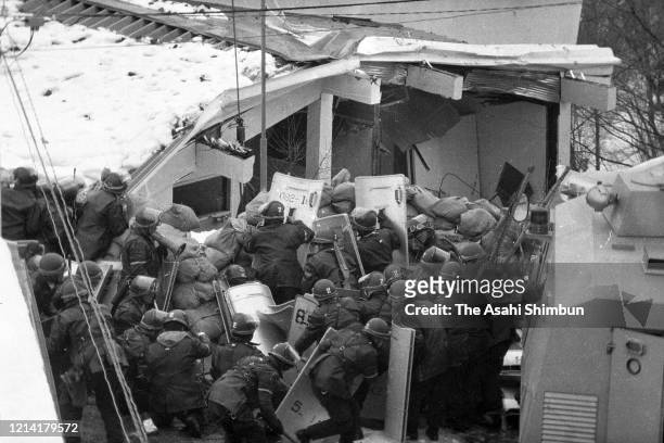 Police destroy the building with an iron ball and water cannon while riot police prepare for storming in as the United Red Army members take a...