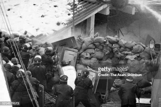 Police destroy the building with an iron ball and water cannon while riot police prepare for storming in as the United Red Army members take a...