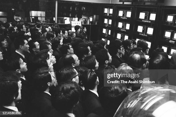 Commuters watch television news as riot police stormed into the Asama Sanso lodge where the United Red Army members take a hostage on February 28,...