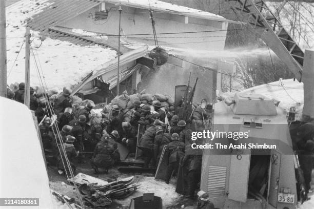 Police destroy the building with an iron ball and water cannon while riot police prepare for storming in as the United Red Army members take a...