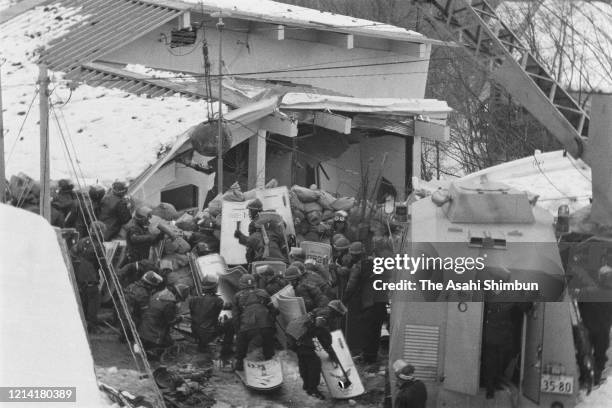 Police destroy the building with an iron ball and water cannon while riot police prepare for storming in as the United Red Army members take a...