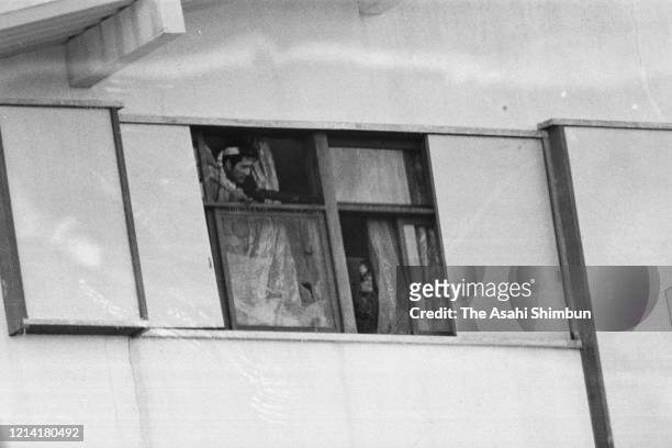 United Red Army members watch outside from the 3rd floor as police use gas bullets and water cannon as the United Red Army members take a hostage at...