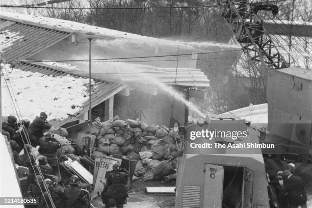 Police destroy the building with an iron ball and water cannon while riot police prepare for storming in as the United Red Army members take a...